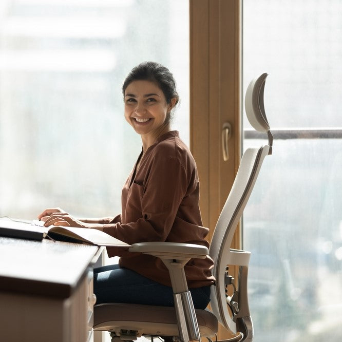 Kvinne som sitter i en komfortabel og ergonomisk kontorstol